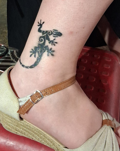 tatouage éphémère de salamandre dans un syle maori de 8cm sur la cheville réalisé à l'arographe et avec un pochoir