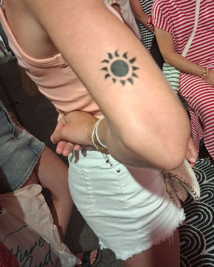 tatouage temporaire aerographe et pochoir représente un petit soleil sur le coude taille du tattoo 5 cm