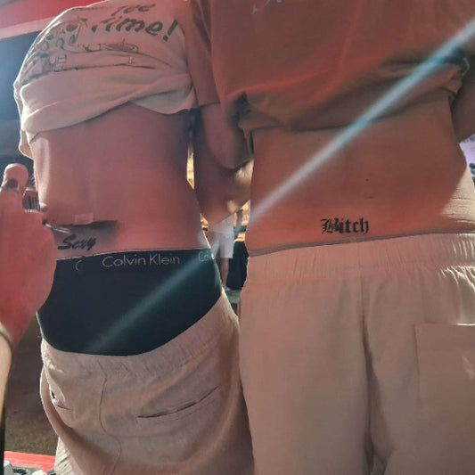 tattoo à l'aéographe sur le bas du dos  2 personnes hommes avec sur le bas du dos un tatouage écrit sexy et un tatouage écrit bitch pour la seconde personnes. airbrush tattoo sexy bitch