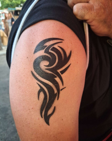 tatouage réalisé à l'aérographe 16 cm sur haut du bras homme représente un motif tribal. été 2026
